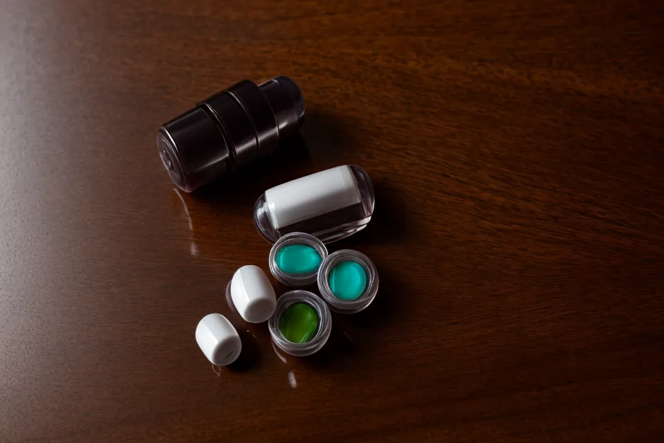 Two eye supplement capsules on a desk next to computer peripherals.